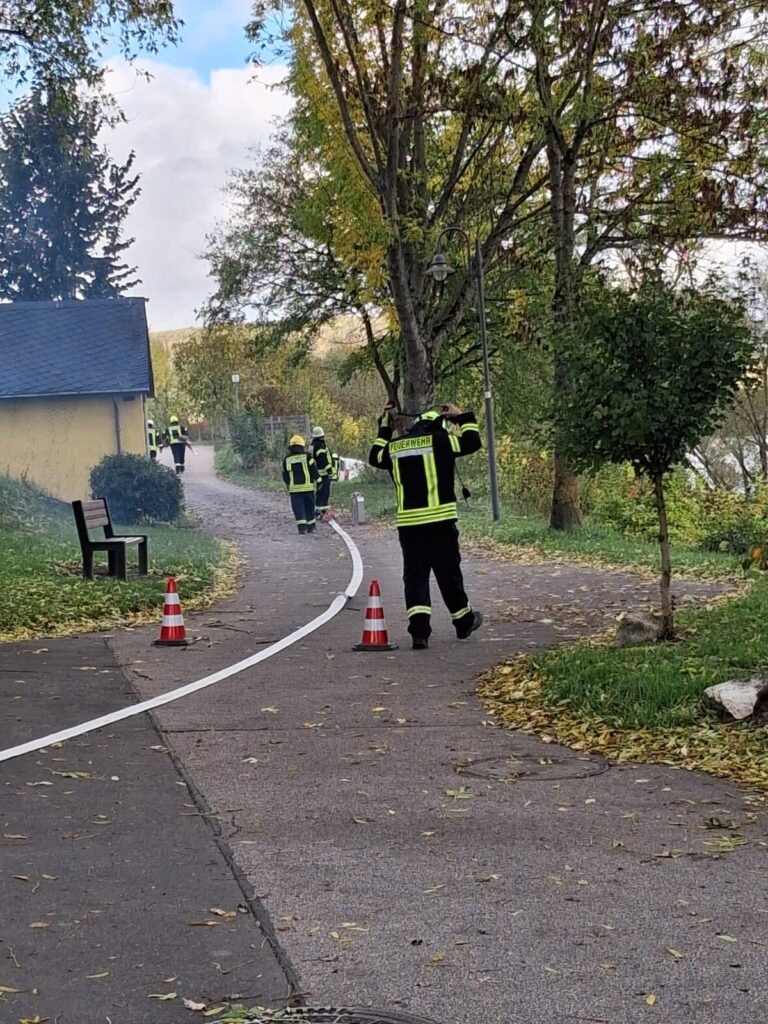 Einsatzkräfte verlegen bei der Abschlussübung 2026 eine Schlauchleitung, um den Brandschutz sicherzustellen